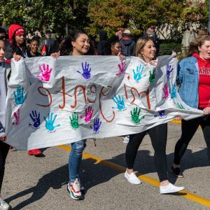 Students in the organization Mi Gente walk in the Homecoming Parade.